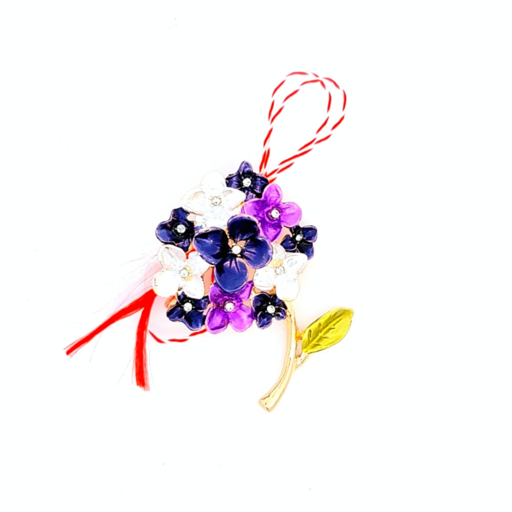 Purple and White Hydrangea Martisor Brooch on a white background, featuring delicate enamelled hydrangea blossoms with golden accents, symbolising spring and renewal, complemented by the traditional red and white Martisor bow.