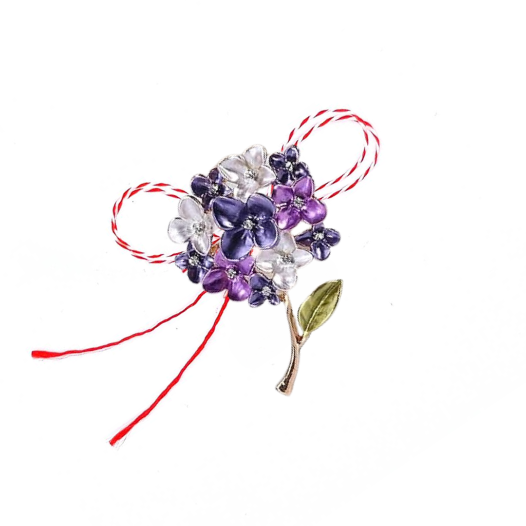 Purple and White Hydrangea Martisor Brooch on a white background, featuring delicate enamelled hydrangea blossoms with golden accents, symbolising spring and renewal, complemented by the traditional red and white Martisor bow.