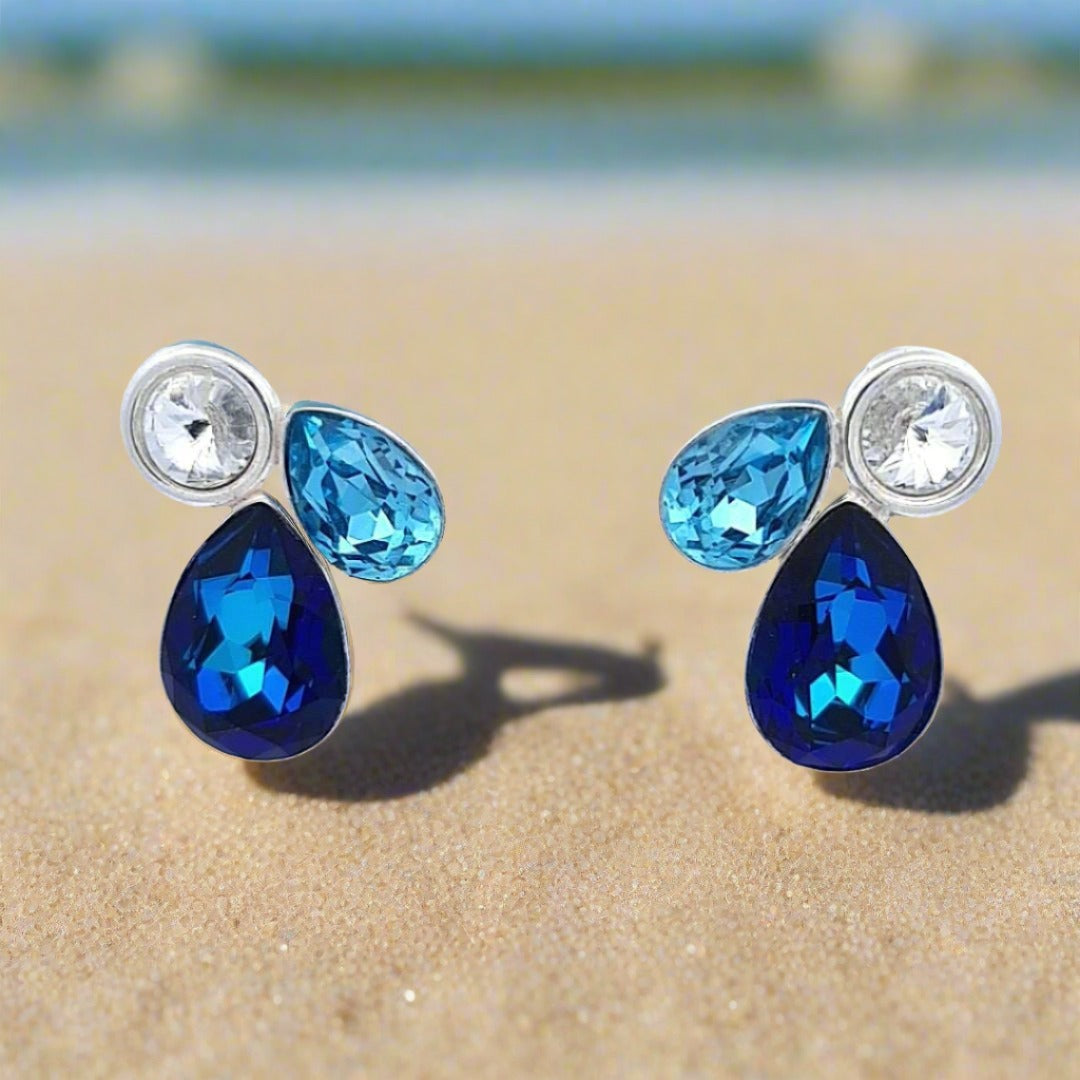 Pair of Infinite Sea Silver Cluster Stud Earrings displayed on a beach background, highlighting their elegance.