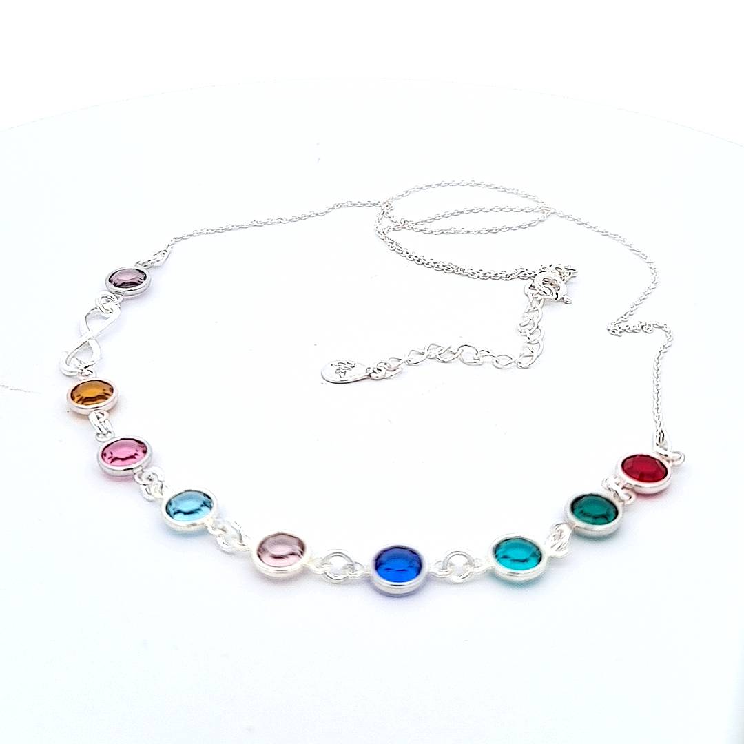 Elegant display of Magpie Gems' 'Legacy of Love' Infinity Necklace with grandmother and grandchildren birthstones, highlighted against a pristine white background for clarity and focus.