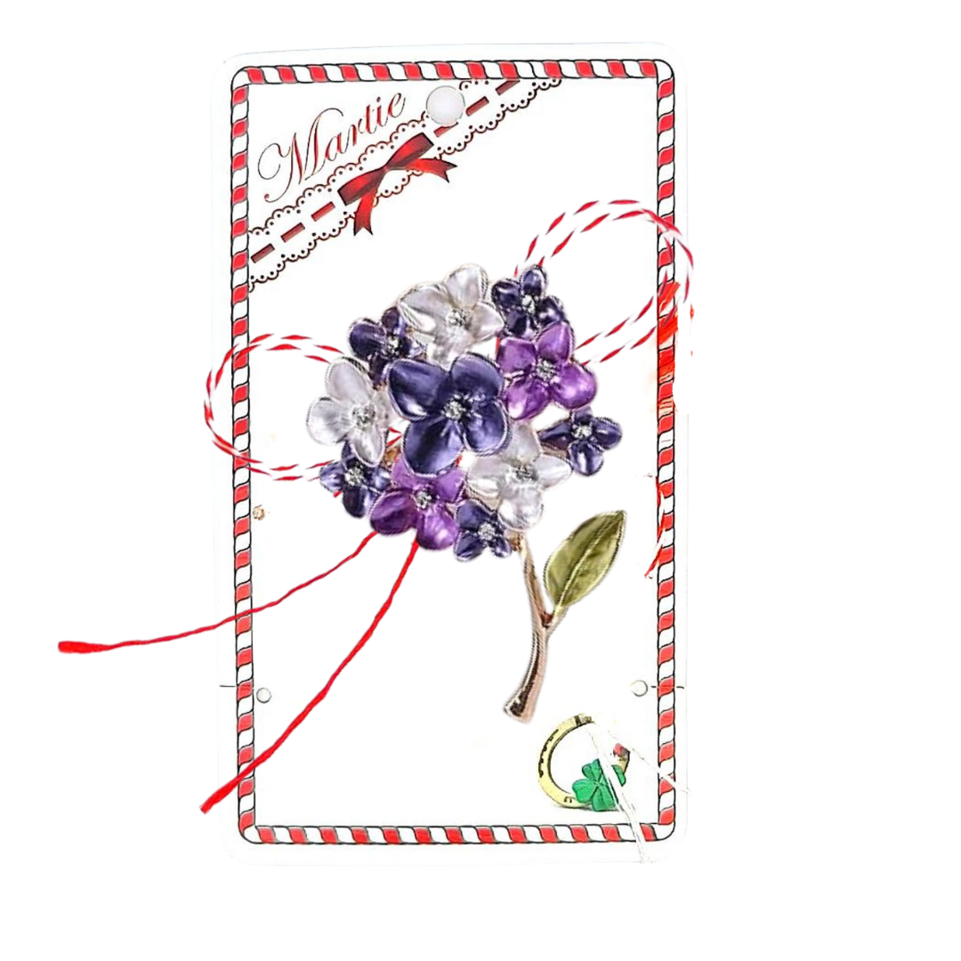 Purple Hydrangea Martisor Brooch displayed on a decorative card with red and white accents, showcasing delicate purple and white hydrangea blossoms with golden accents and a green leaf, paired with the traditional red and white Martisor bow, celebrating spring traditions.