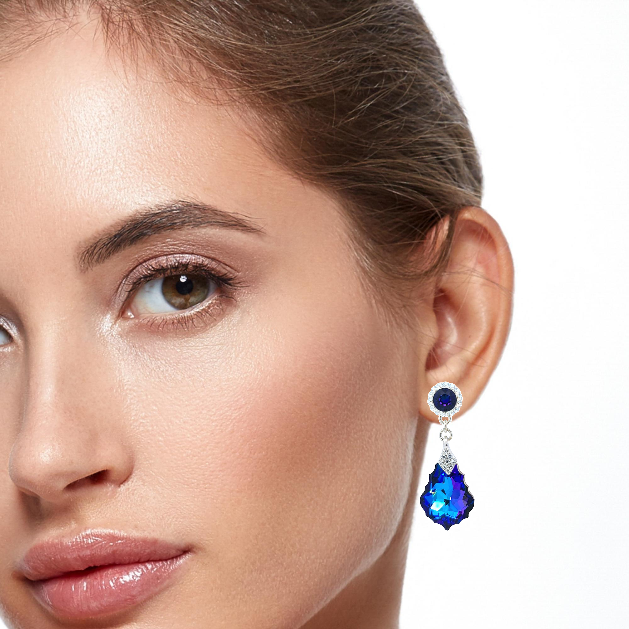 A woman elegantly wearing the Heliotrope Baroque Drop Stud Earrings, showcasing their captivating blue and purple crystals, handmade in Ireland by Magpie Gems