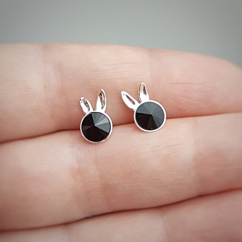 Sterling Silver Bunny Stud Earrings held by hand highlighting the jet black crystal and whimsical design.